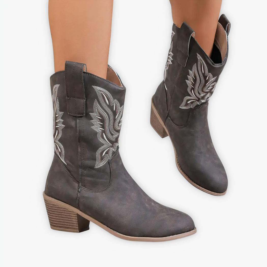 Santiag basse femme rétro grise style cowboy, avec broderie blanche, porté par une femme sur fond gris