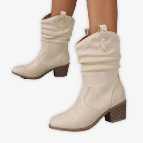 Santiag beige intemporelle et sophistiquée portée par une femme sur fond gris