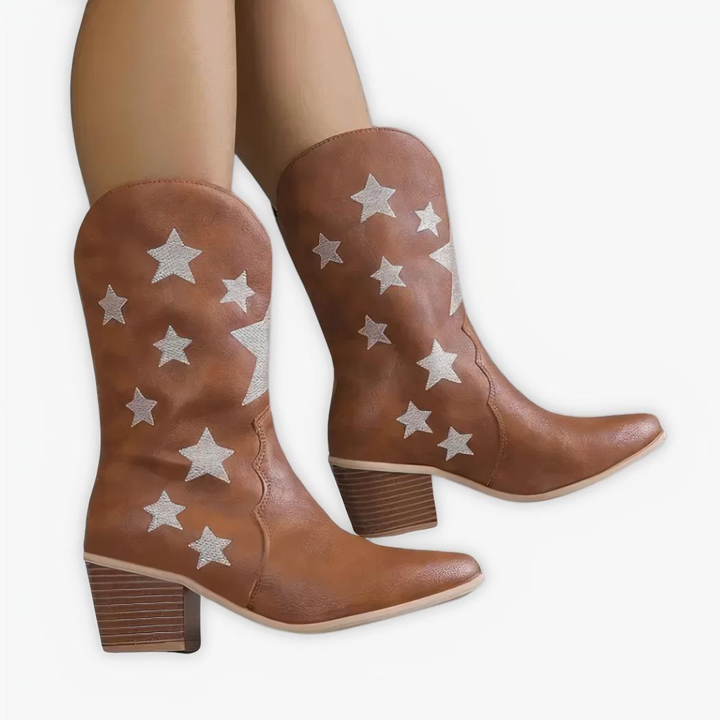 Santiag courte femme style cowboy avec motifs étoiles, de couleur marron, porté par une femme sur un fond gris.