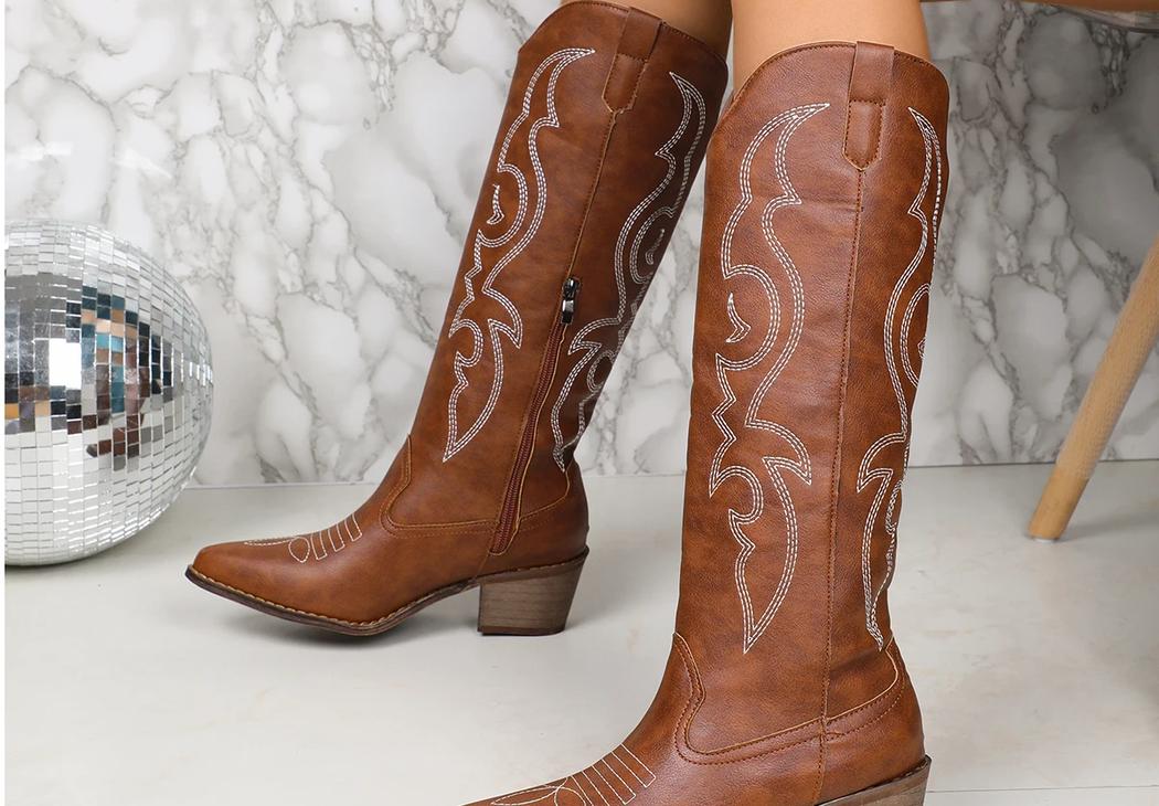 Santiag femme mi mollet marron avec broderies, avec petit talon, porté par une femme.