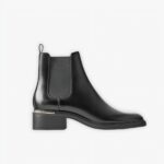 Santiag noire classique et minimaliste en cuir sur fond gris