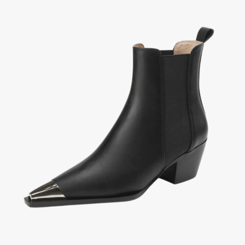 Santiag bout métal pour femme en cuir avec petit talon noir sur fond gris très clair. Le bout est pointu et la hauteur va jusqu'à la cheville.